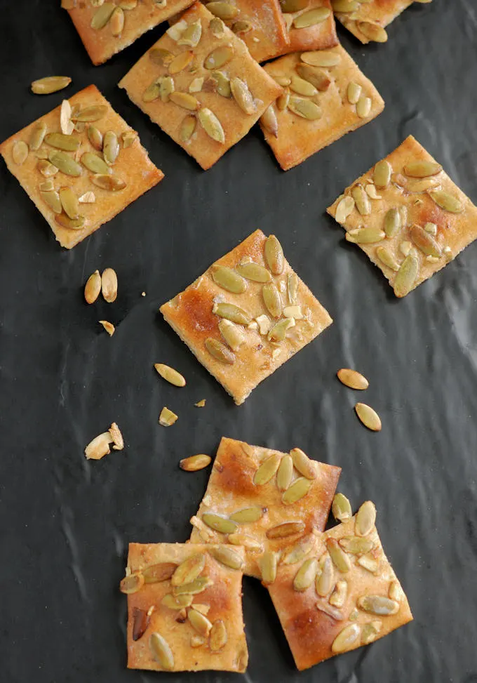 pumpkin seed crackers on a black surface