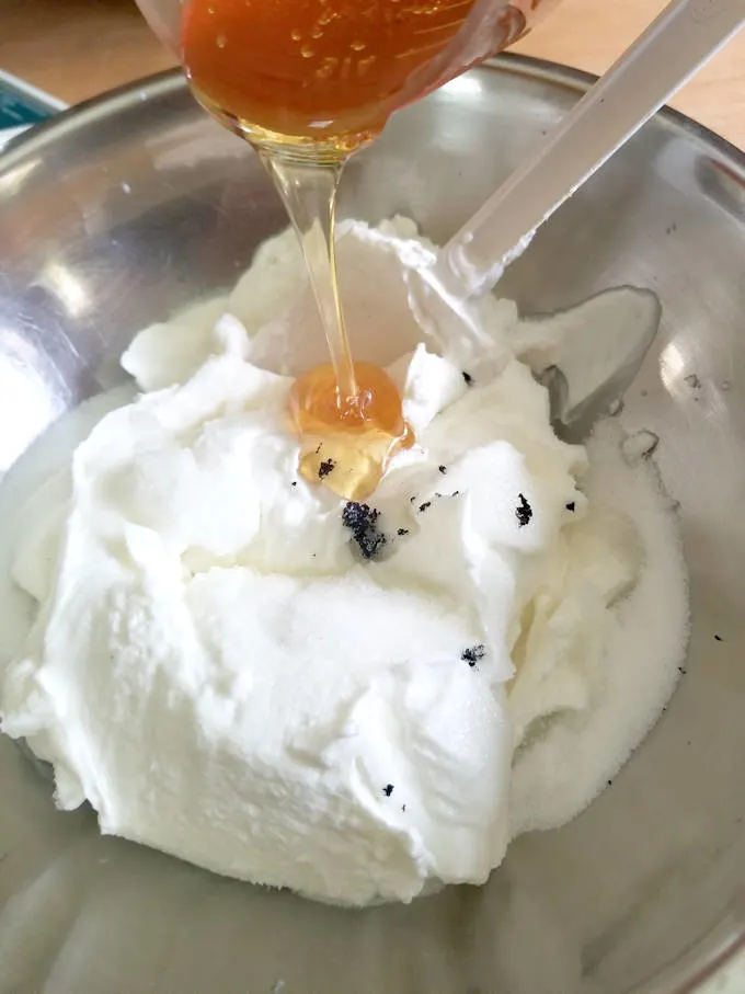 pouring honey into yogurt