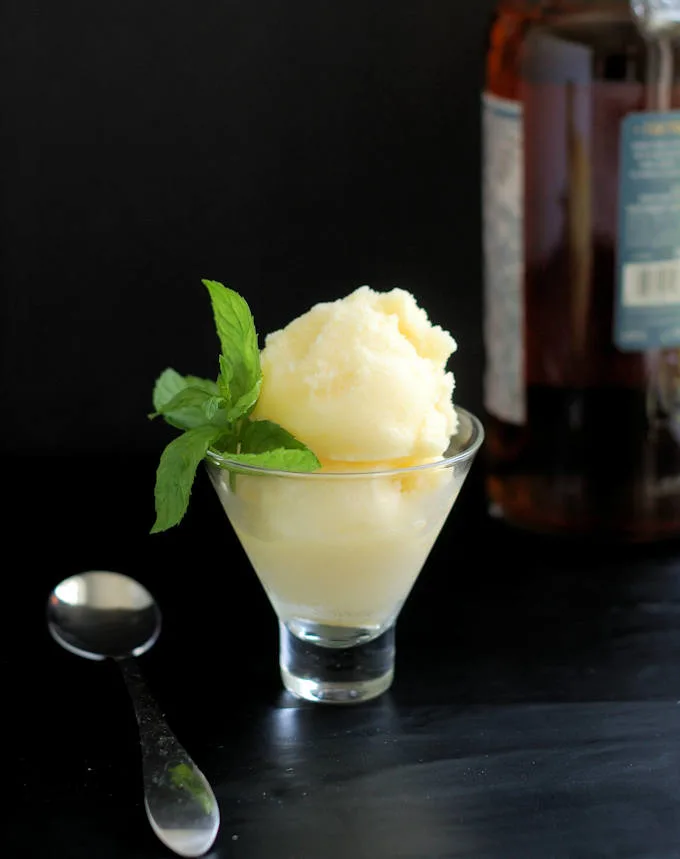a glass filled with homemade pineapple sorbet and a sprig of mint