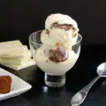 an ice cream dish filled with white chocolate ice cream with chocolate truffles.
