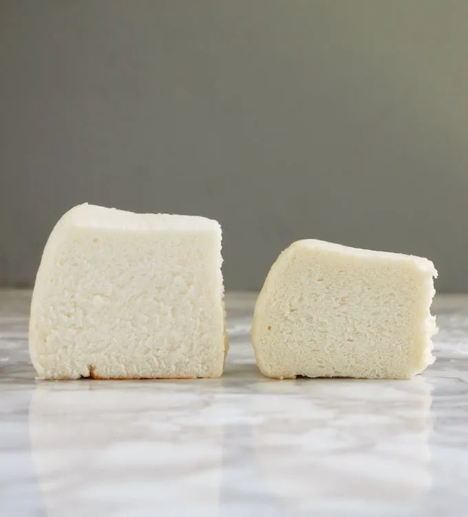 Two slices of angel food cake on a marble table.