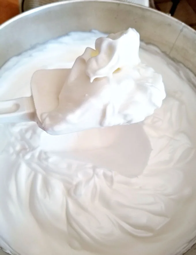 The photo shows a bowl of perfectly whipped meringue for angel food cake