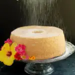 an angel food cake on a cake stand with text overlay