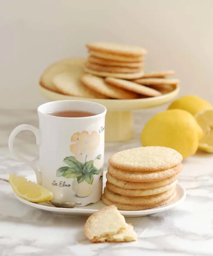 lemon thin cookies and a cup of tea on a table 