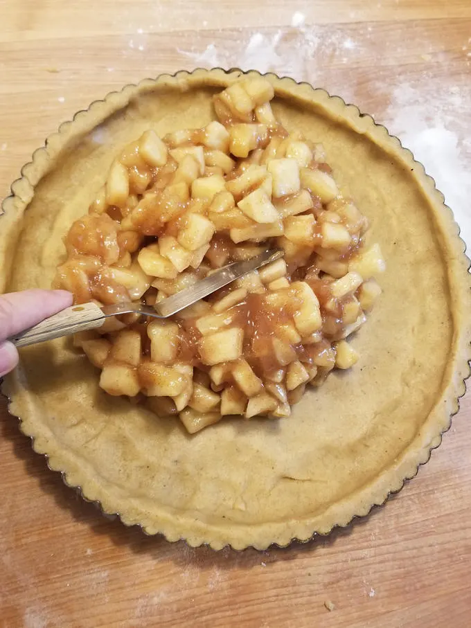 spread the precooked filling into the shell for apple walnut linzer tart