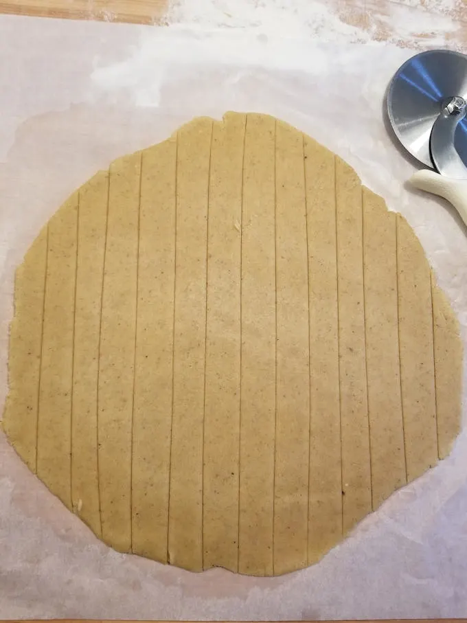 cut strips of dough to make a lattice top on apple walnut linzer tart