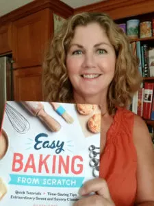 Author holding copy of cookbook