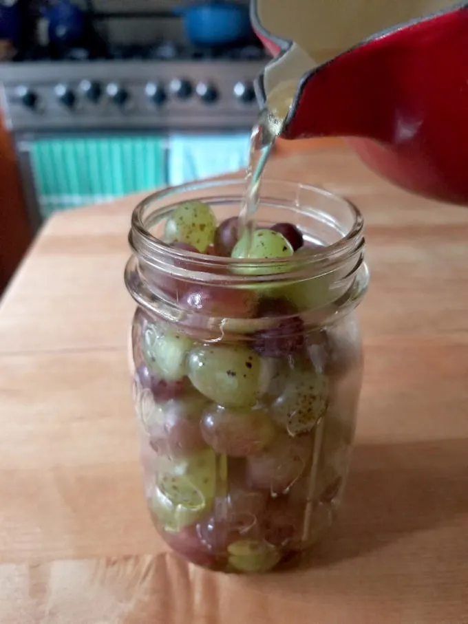 pouring bring over grapes in a jar