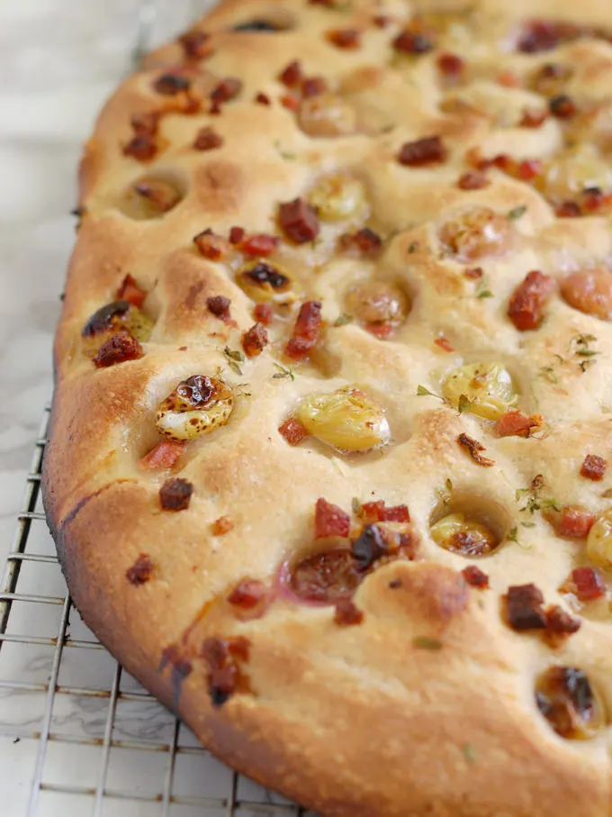 closeup shot of focaccia with pickled grapes and speck