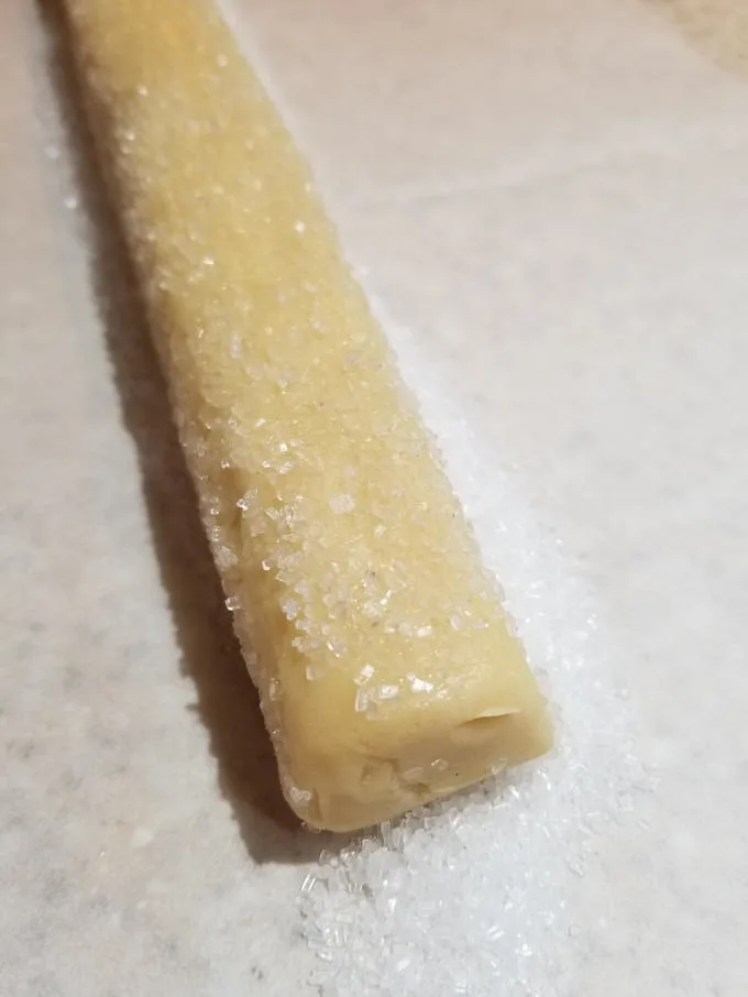 rolling cookie dough in crystal sugar 