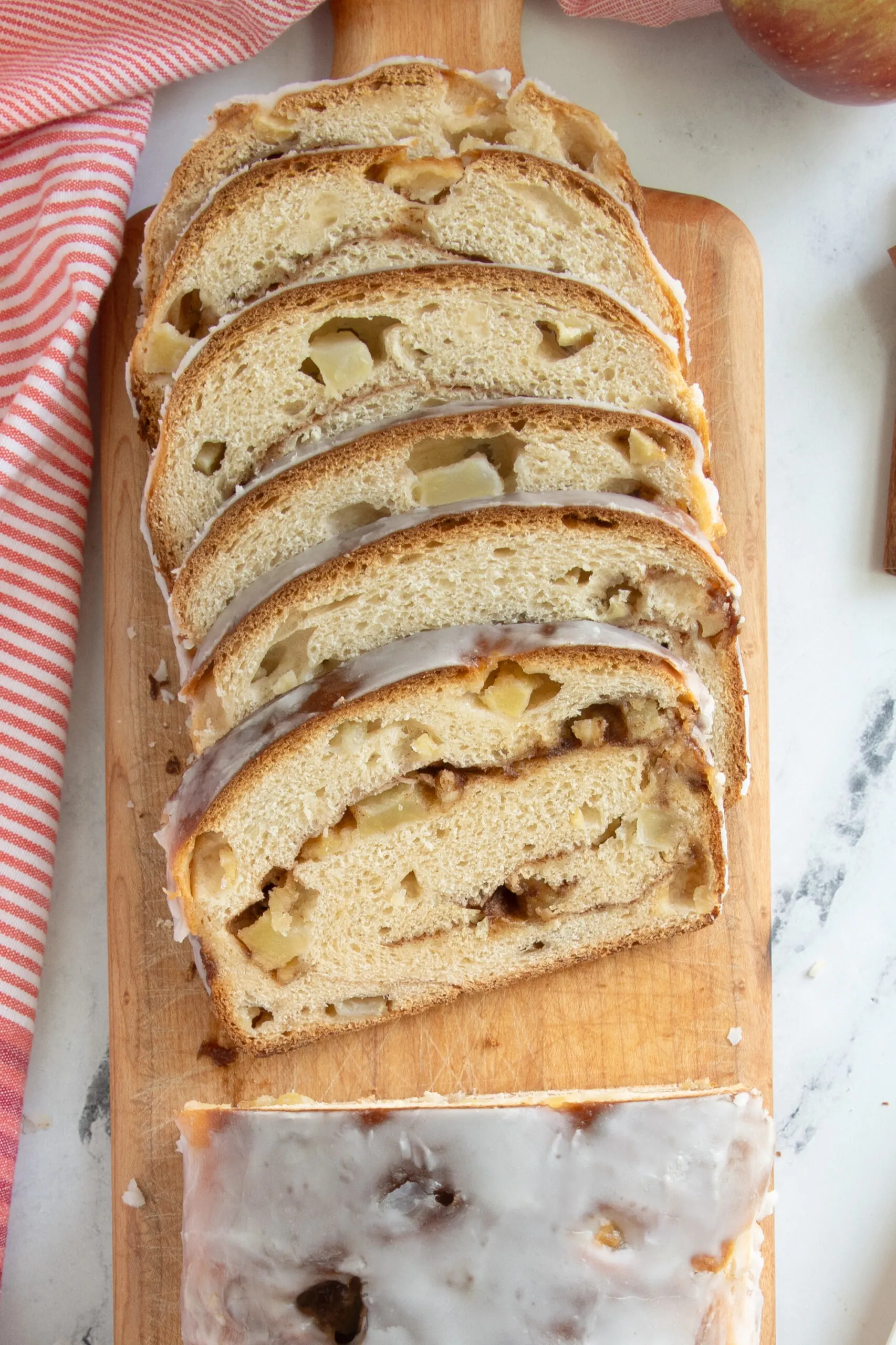 a sliced loaf of apple cinnamon bread on a cutting board.