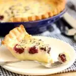 a slice of blackberry buttermilk pie on a white plate with a fork