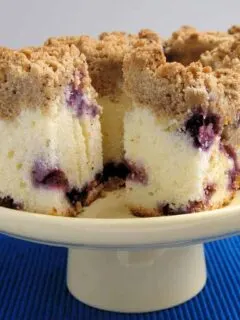 a Blueberry Crumb Cake on a cake stand