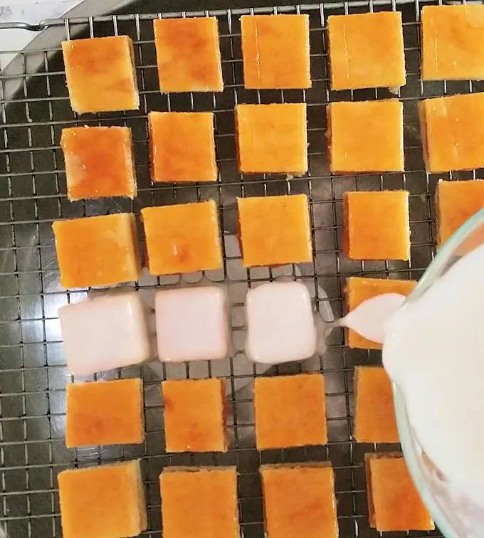 pouring fondant icing over petit fours