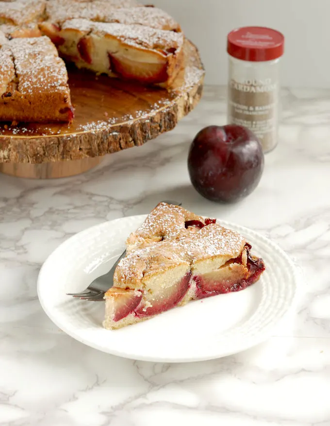 a slice of rustic plum cake with cardamom