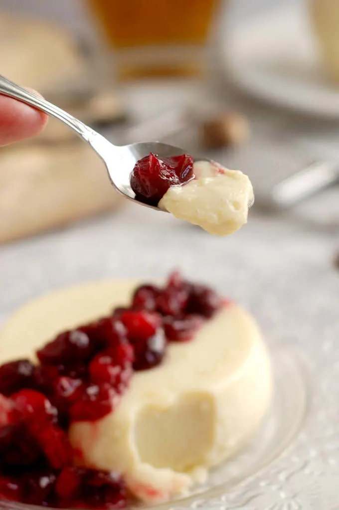 a spoonful of eggnog panna cotta with cranberries