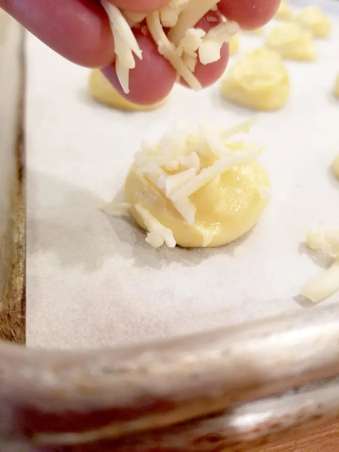 sprinkling cheese onto dough