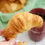 a hand holding a sourdough croissant