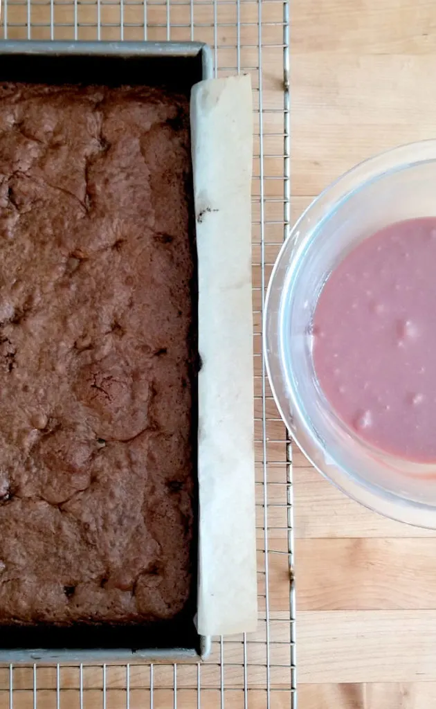 a pan of chocolate cherry brownies and a bowl of cherry ganache