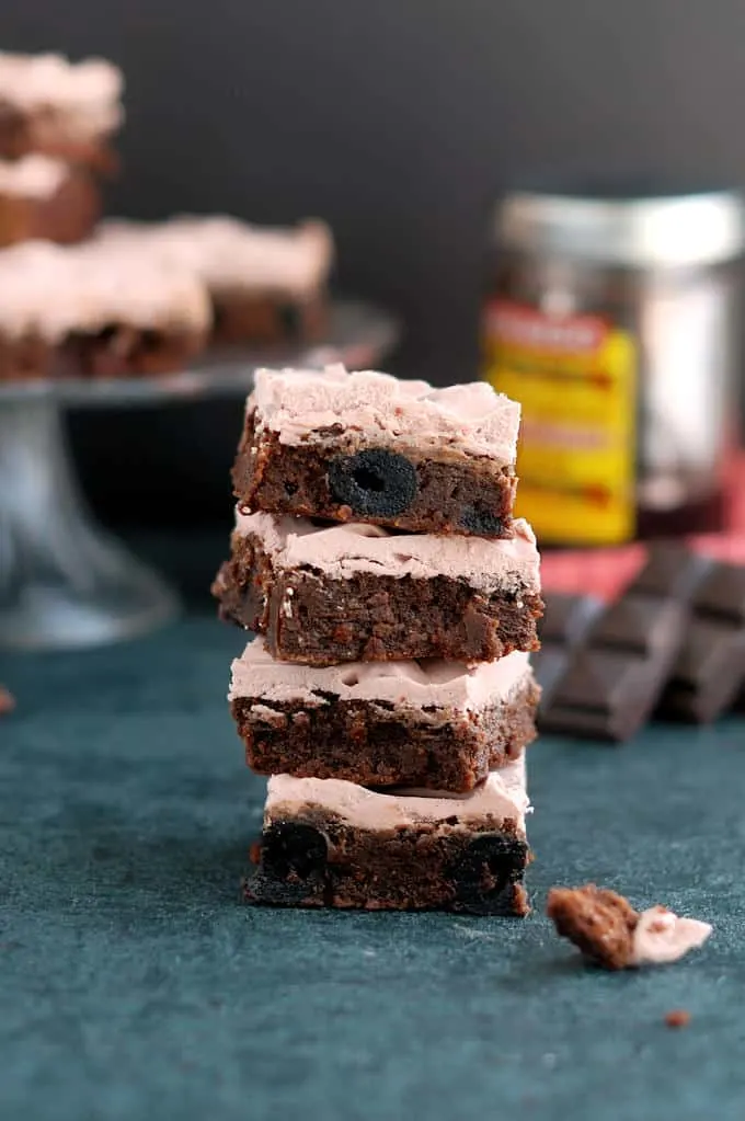 a stack of Chocolate Cherry Brownies with cherry frosting