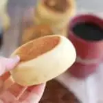 a hand holding a sourdough english muffin