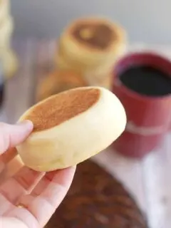 a hand holding a sourdough english muffin