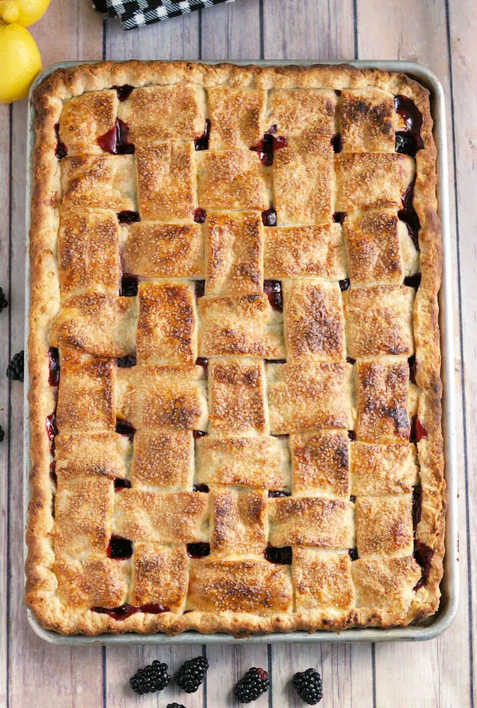 A half sheet pan pie with a lattice crust on a wooden table.