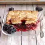 a slice of berry pie on a glass plate