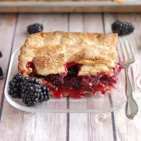 a slice of berry pie on a glass plate
