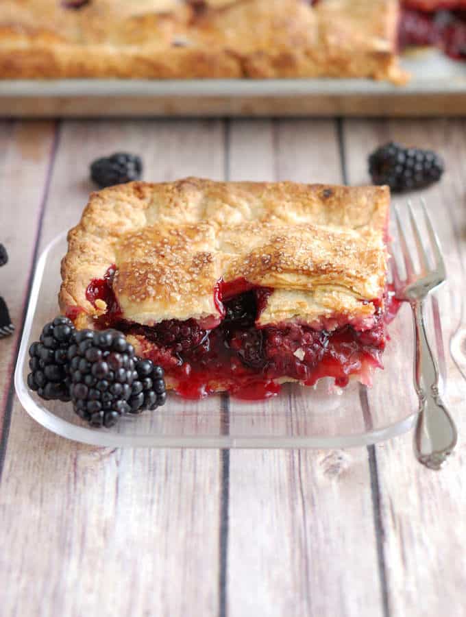 a slice of berry pie on a glass plate