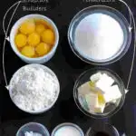 The assorted ingredients for cake batter in bowls on a black background. White text overlay says The Bakers Formula for Perfect Cake Recipes