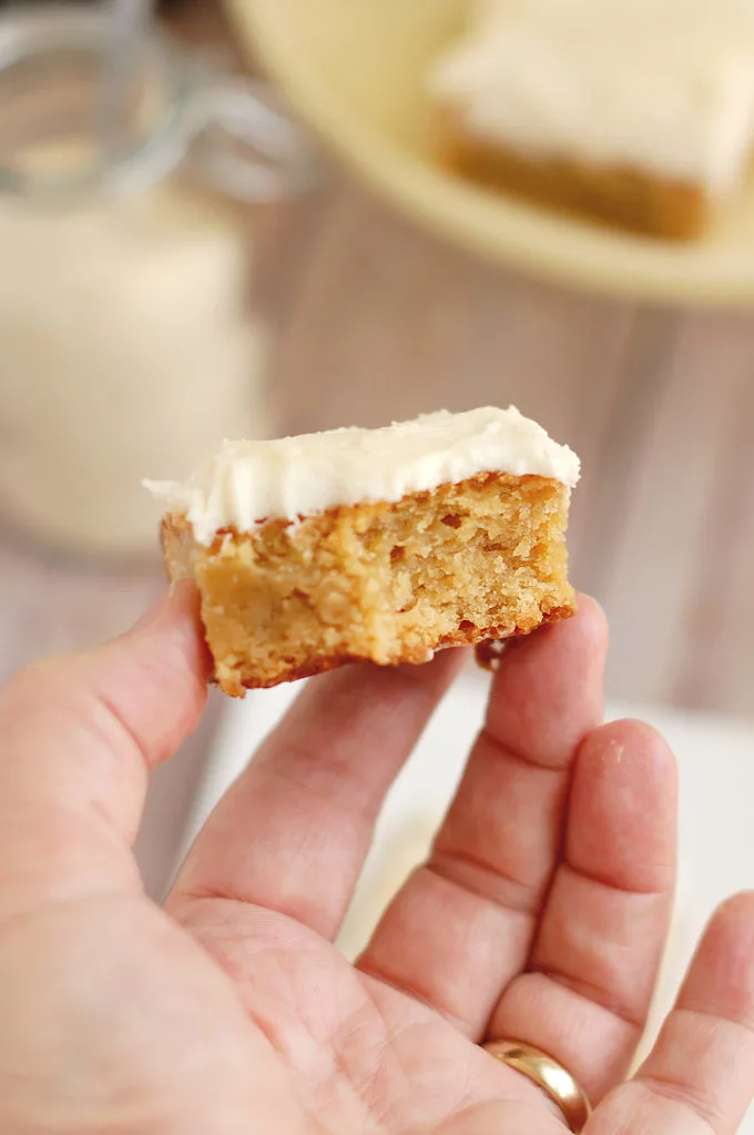 a hand holding a half eaten blondie bar.