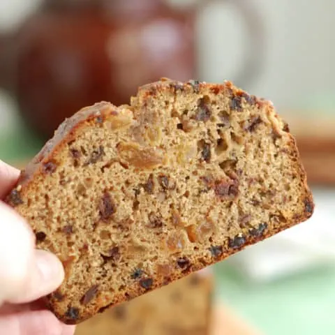 a hand holding a slice of Irish Tea Brack
