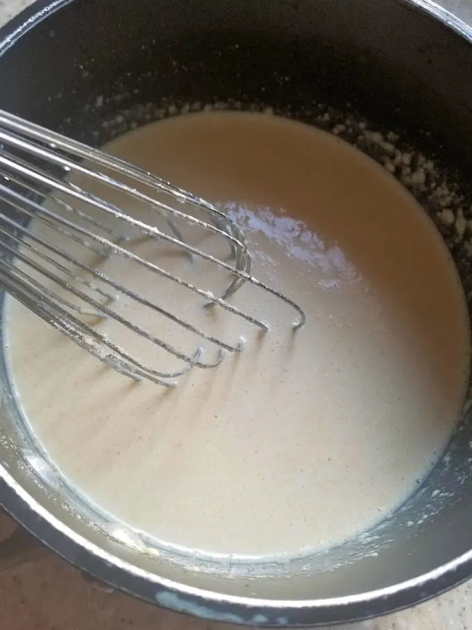 a pot of malted milk with a whisk