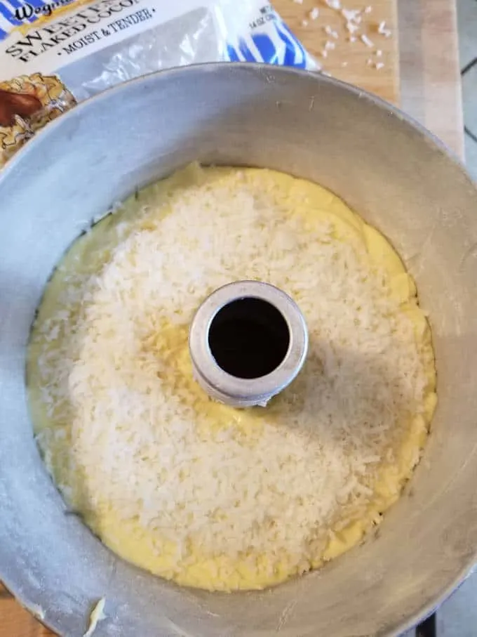 a cake pan filled with batter and shredded coconut