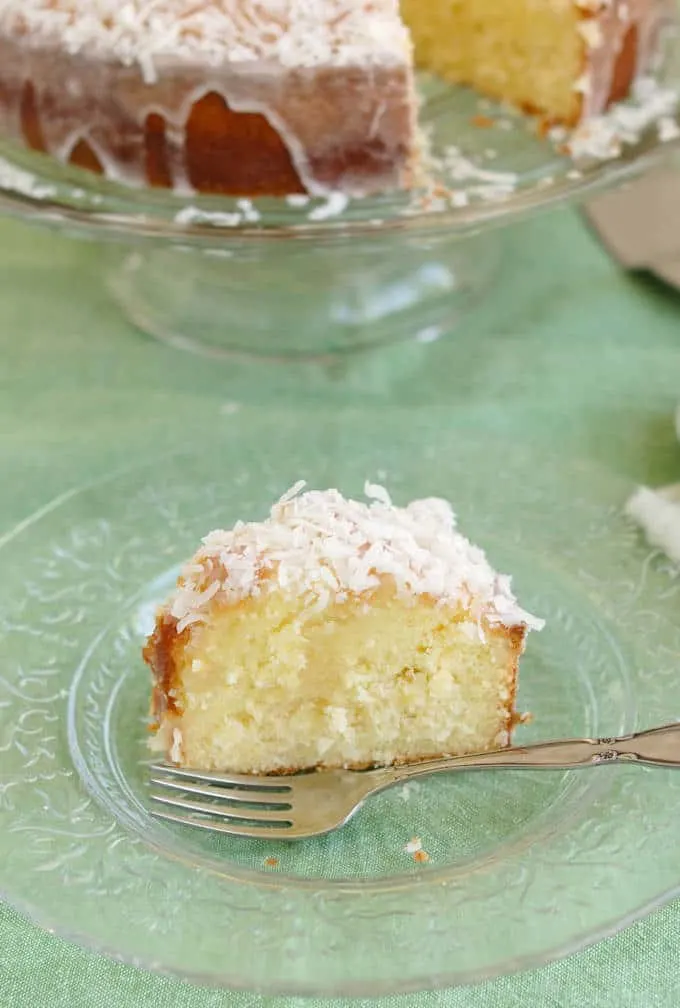 a slice of coconut pound cake on a plate with a fork.