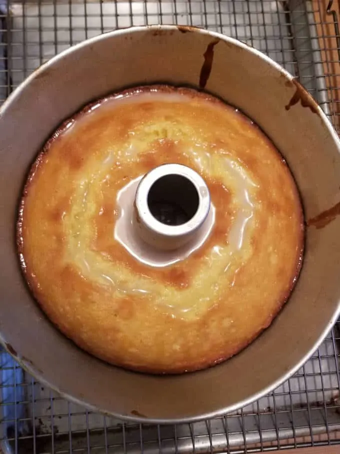 A baked cake in a pan with syrup soaking in.