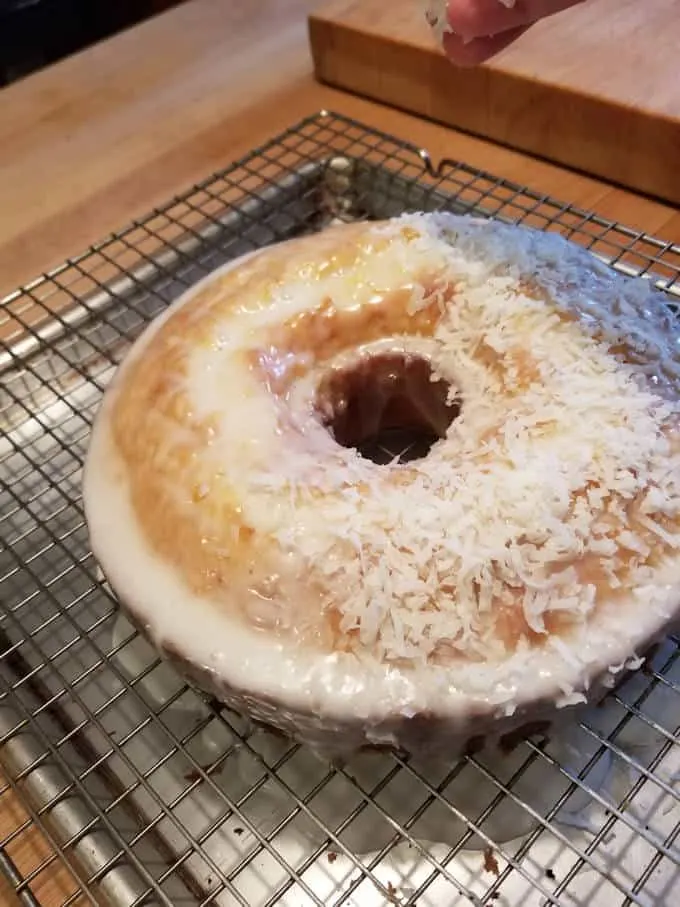 Coconut being sprinkled on a cake