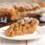 a slice of rhubarb crumb pie on a white plate