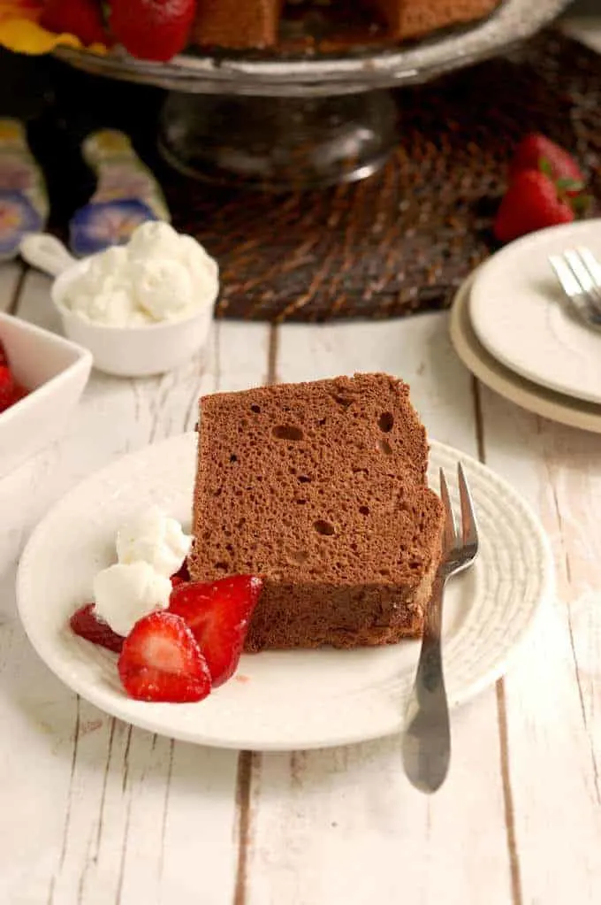 a slice of chocolate angel food cake on a plate with cream and strawberries