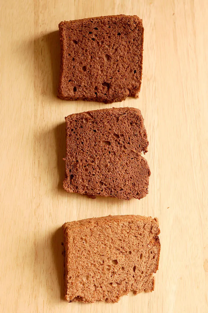 three slices of chocolate angel food cake on a wood table.