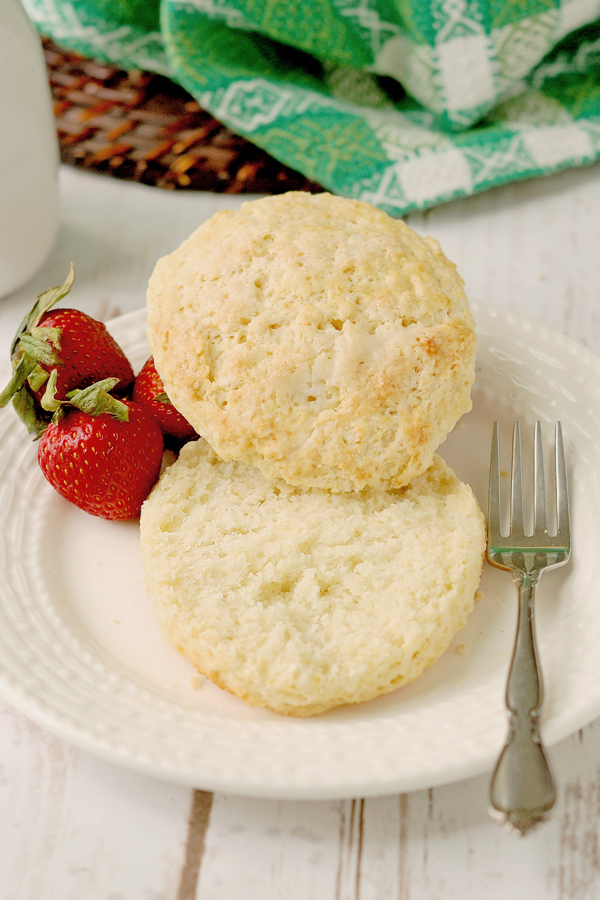 a split shortcake biscuit on a white plate.