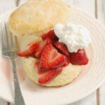 a strawberry shortcake on a white plate.