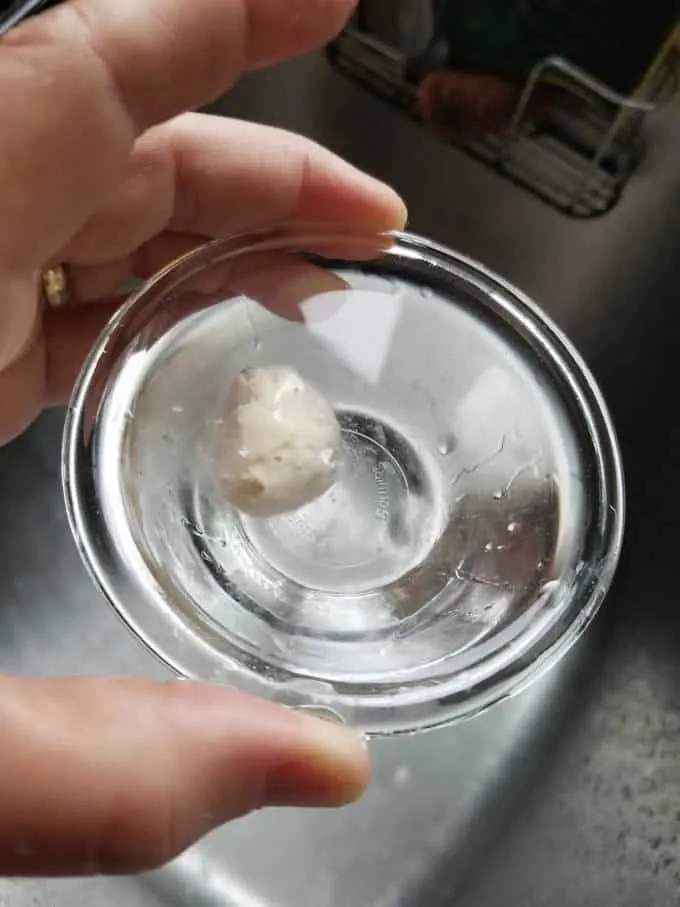 a dollop of sourdough starter floating in a bowl of water