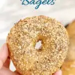 an image of a hand holding a sourdough bagel with text overlay for pinterest