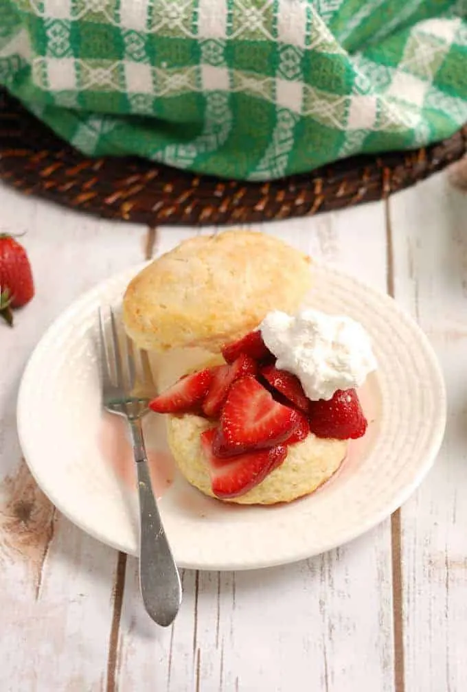 a plate with a strawberry shortcake with cream