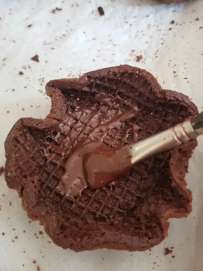 brushing melted chocolate into a waffle bowl