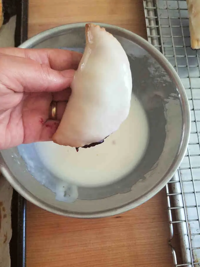 a hand pie freshly dipped in lemon glaze