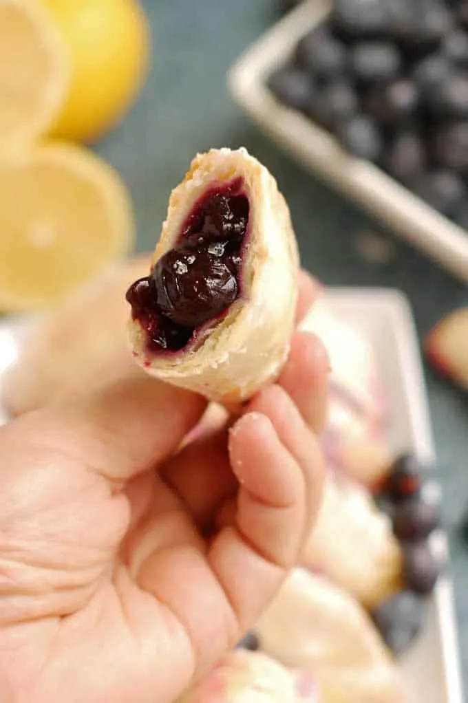 a hand holding a blueberry hand pie