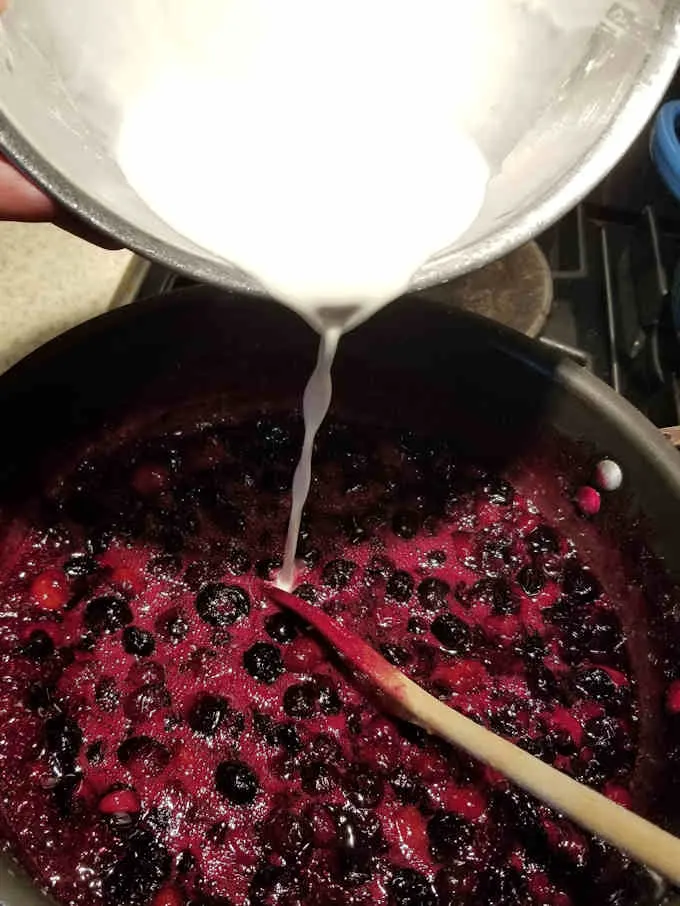 adding cornstarch slurry to blueberries